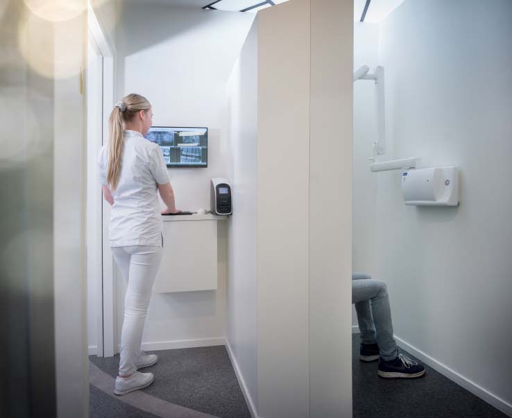 vrouw bekijkt rontgenfoto op een computerscherm