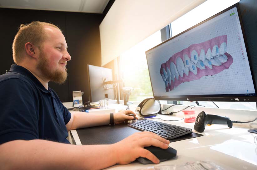 man die werkt aan een prothese op een computerscherm